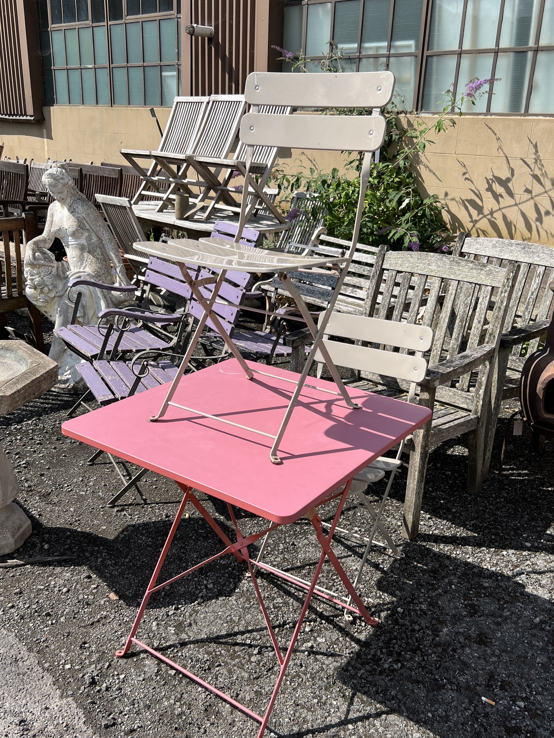 A square painted metal folding garden table, width 71cm, height 71cm and two metal folding garden chairs